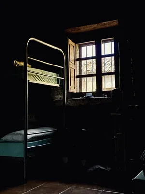 Pielgrzym odpoczywa na piętrowym łóżku w albergue